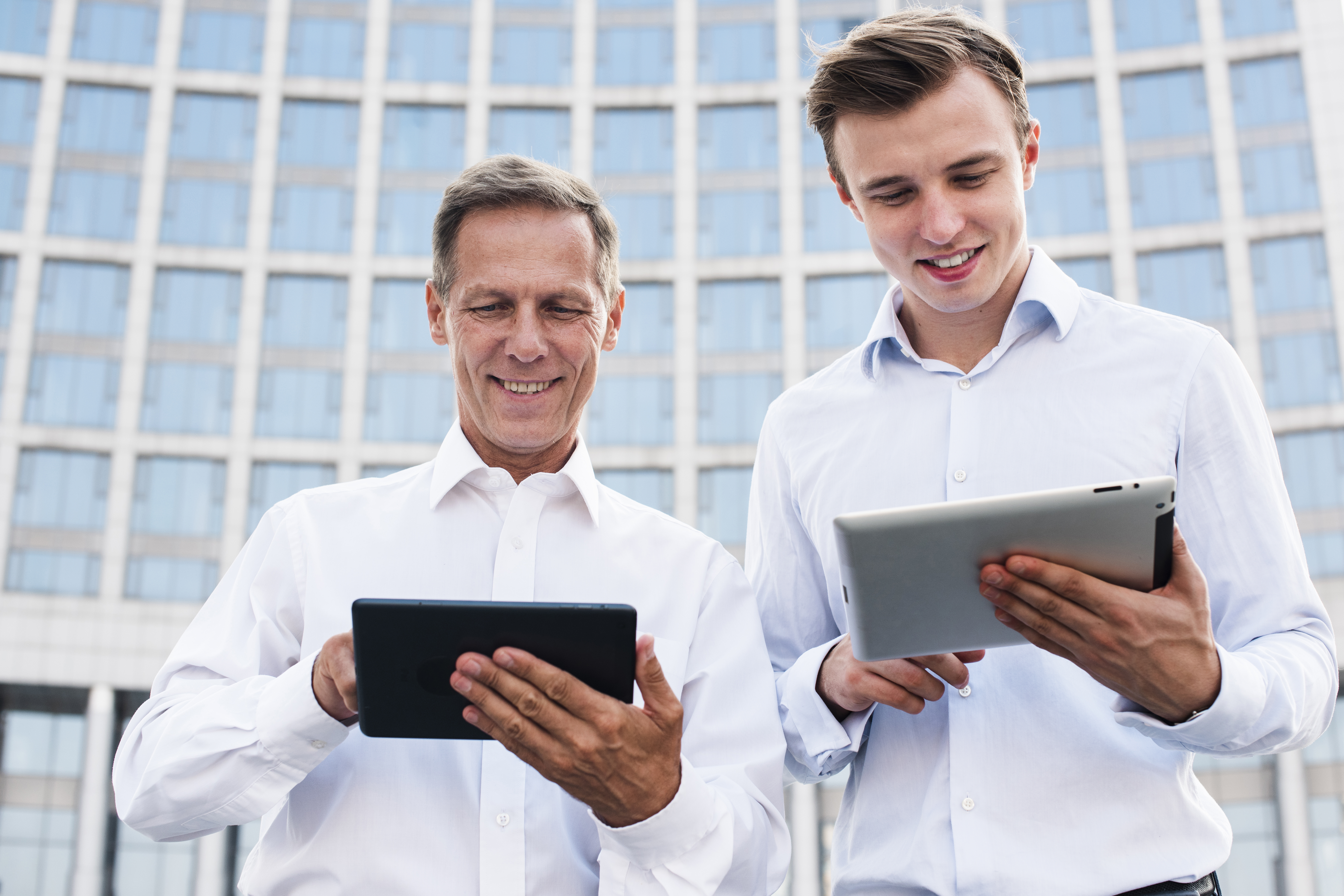 low-angle-businessmen-looking-tablets